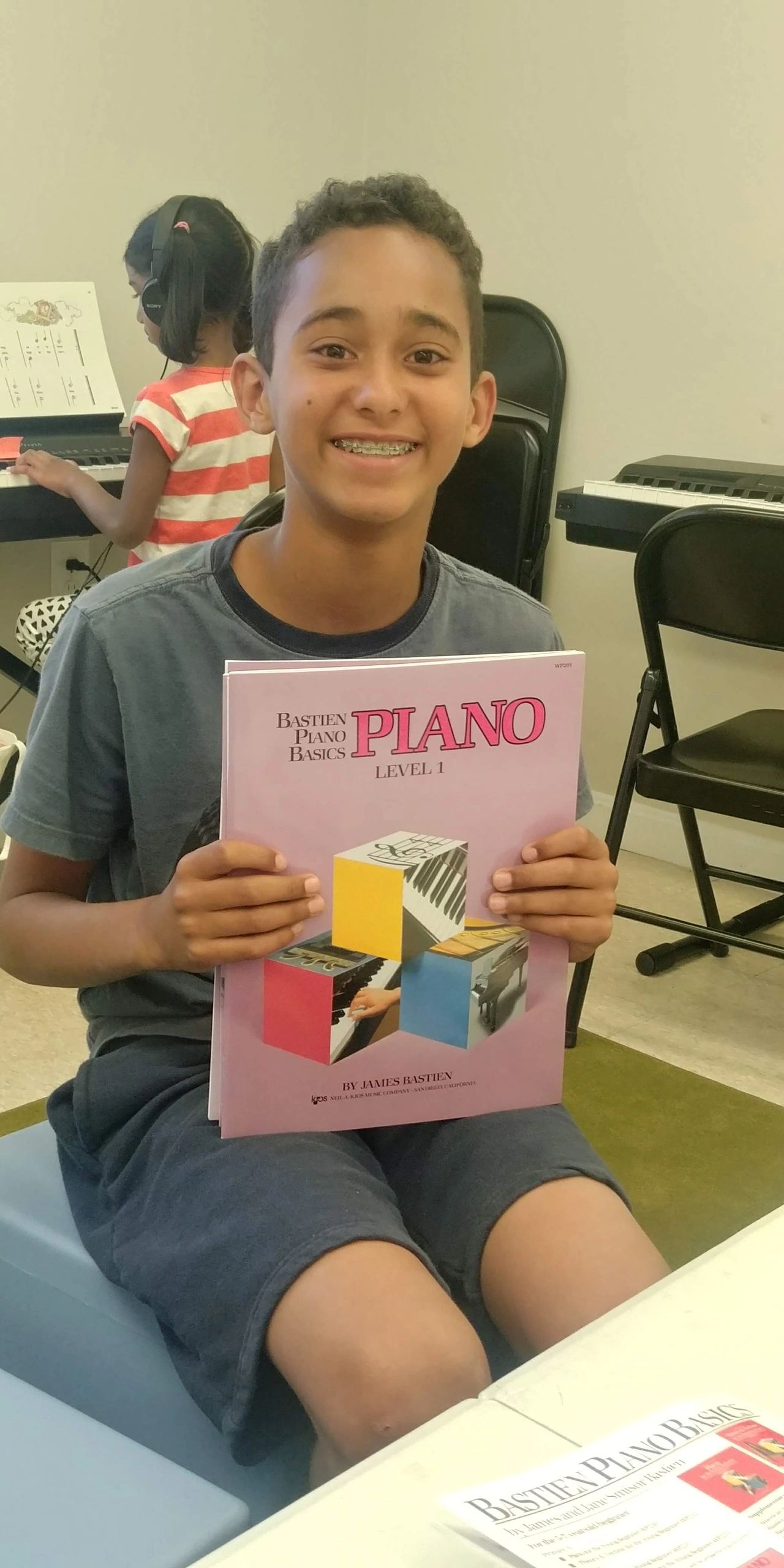 Student smiling holding piano music book